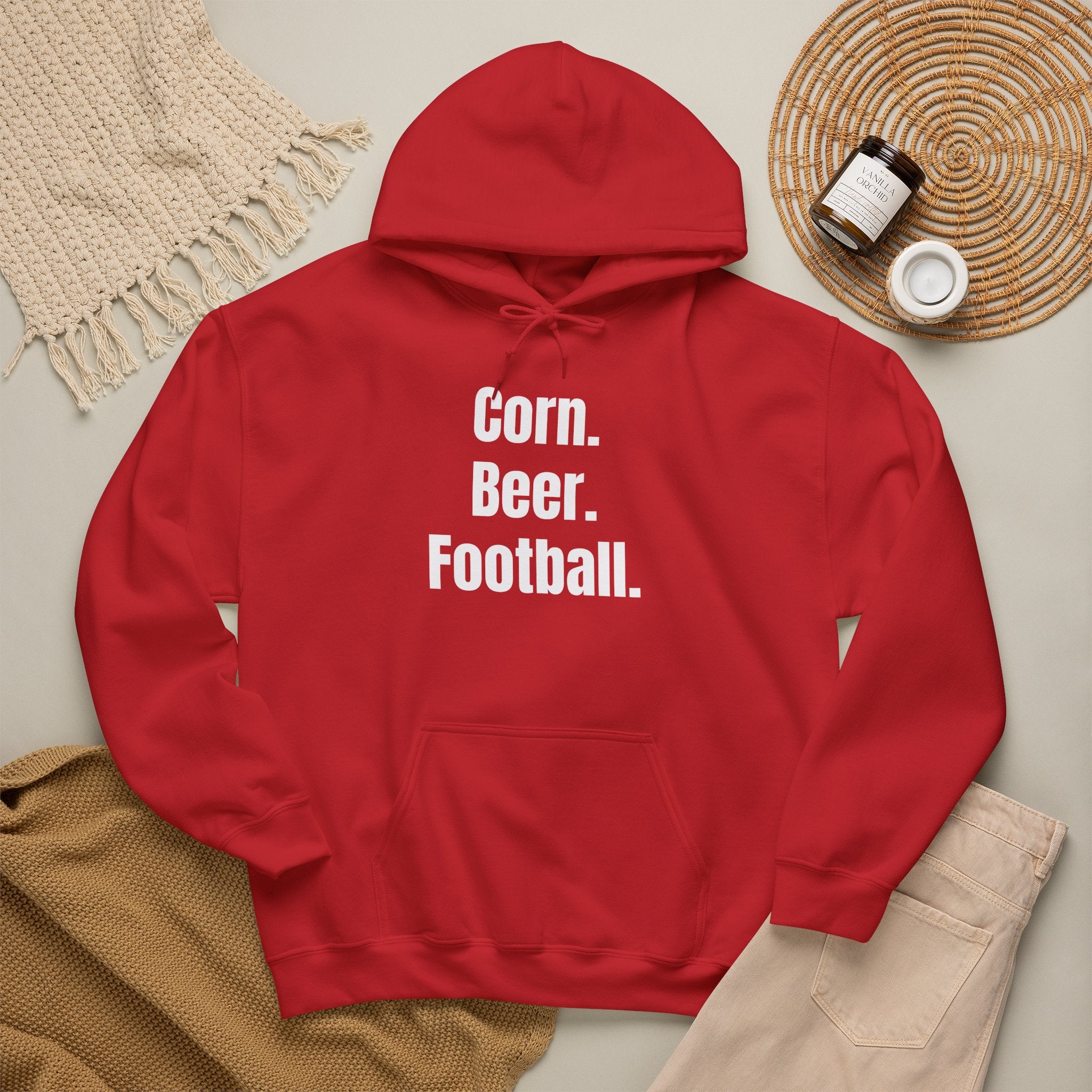 Red hoodie with 'Corn. Beer. Football.' text on a neutral background